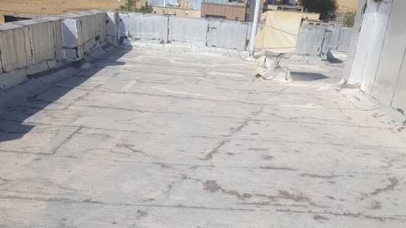 نمای ایزوگام پشت‌بام با پوسیدگی و آسیب‌دیدگی قبل از اجرای ترمیم